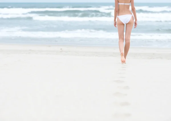 Menina magro em maiô branco caminhando para o oceano . — Fotografia de Stock