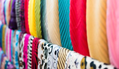 Row of new multicolored scarves at shop.