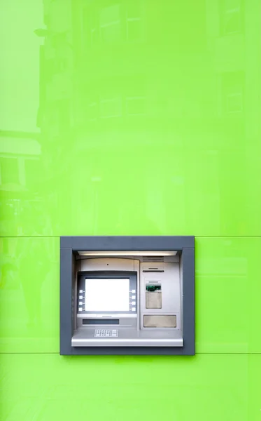 在绿色的墙体在阳光下闪耀的自动取款机. — 图库照片