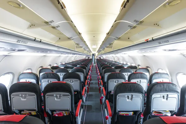 Vanishing row of black and red seats in airplane. — Stock Photo, Image