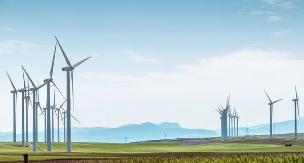 在绿色的原野在蓝蓝的天空上的风力涡轮机. — 图库照片