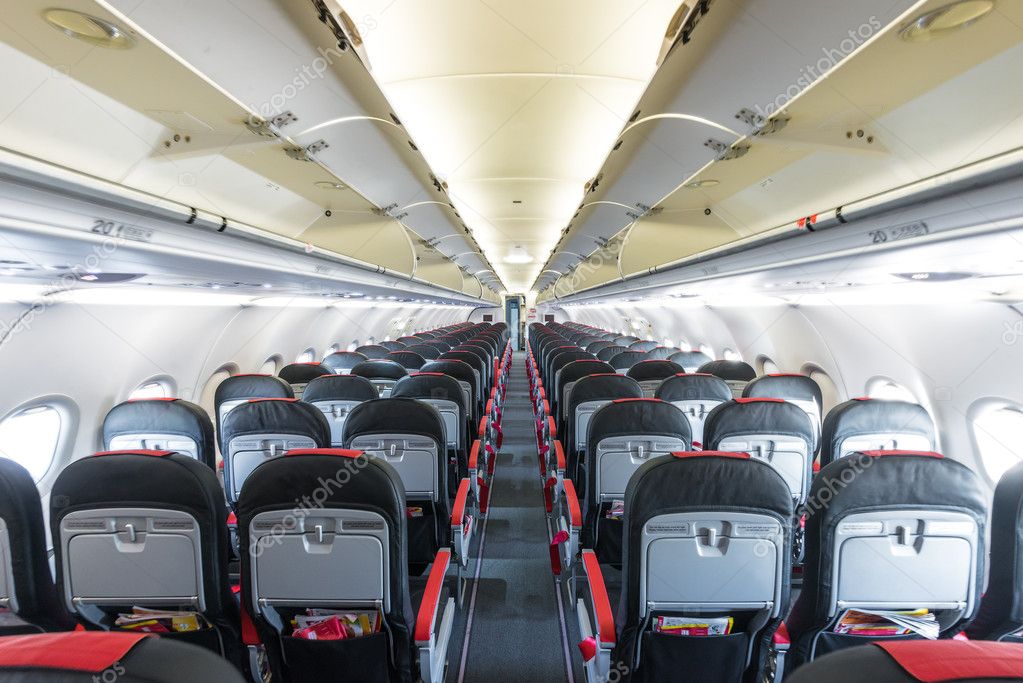 Vanishing row of black and red seats in airplane.