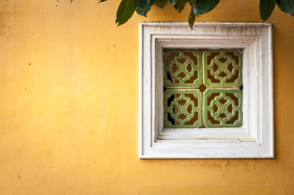 Okno na ścianie żółtego stiuku — Zdjęcie stockowe