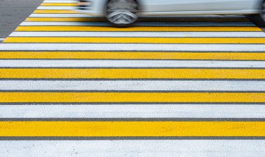 Sarı ve beyaz yaya geçidi ve araba