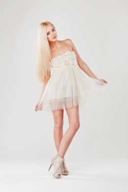 Beyaz elbiseli seksi güzel genç sarışın kadın