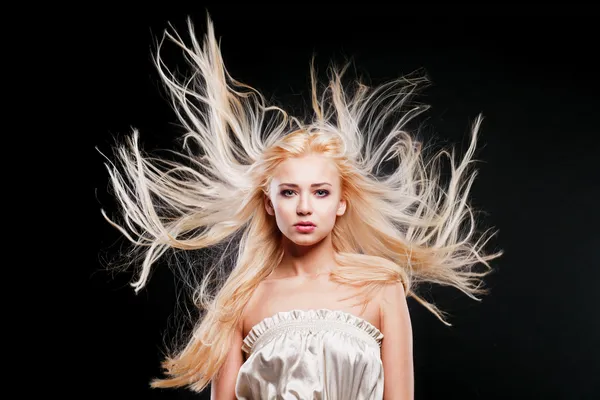 Modeporträt der schönen Blondine mit den fliegenden Haaren lizenzfreie Stockfotos
