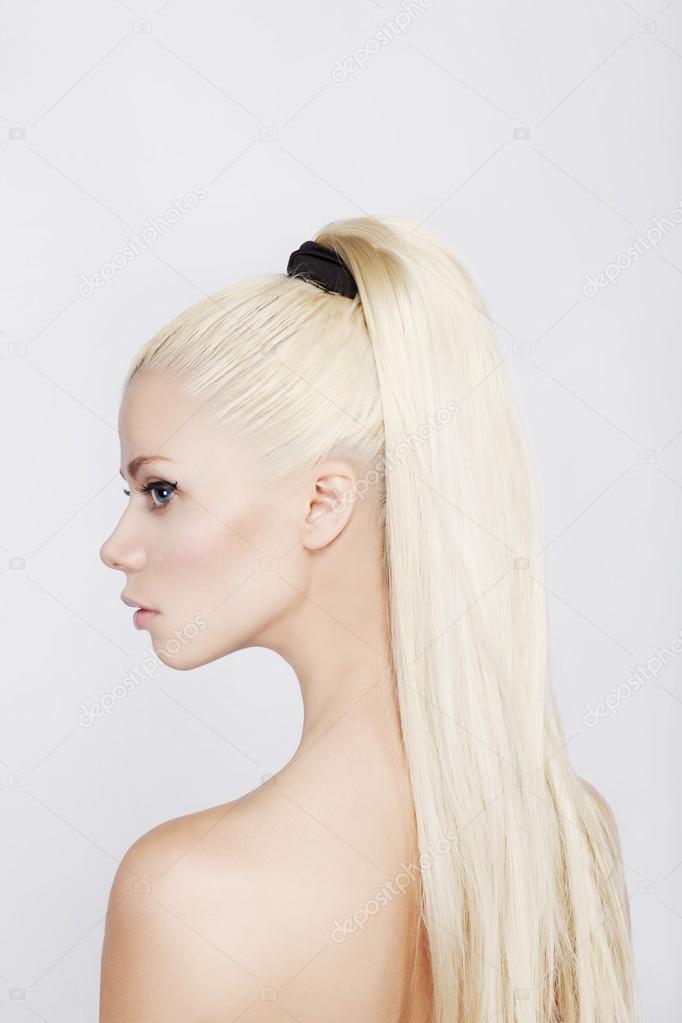 Portrait of the beautiful blonde woman with a long tail. Profile