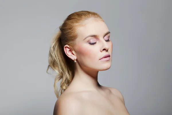 Closeup beauty portrait of a blond lady with on grey background — Stock Photo, Image