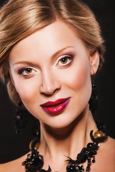 Prachtige model met make-up, rode lippen en dragen zwarte sieraden — Stockfoto