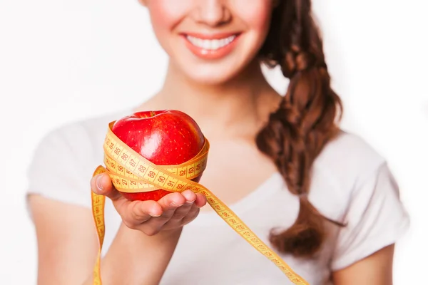 Femme souriante tenant une pomme et un mètre ruban — Photo