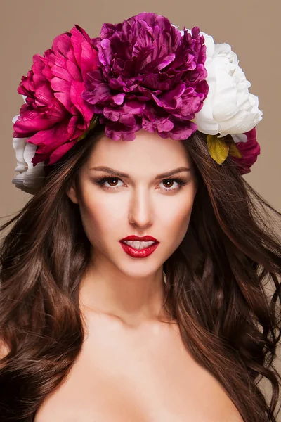 Mooie vrouw met heldere bloemen op haar hoofd — Stockfoto