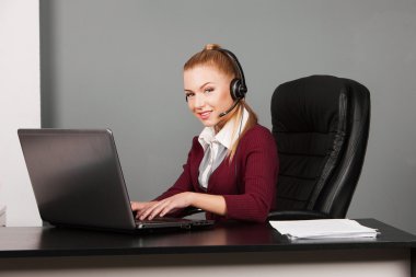 güzel genç destek telefonu operatörü kulaklık, ofis içinde gülümseyen