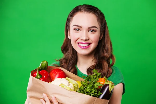 Schöne lächelnde Frau mit Tasche voller frischer und gesunder Lebensmittel. — Stockfoto