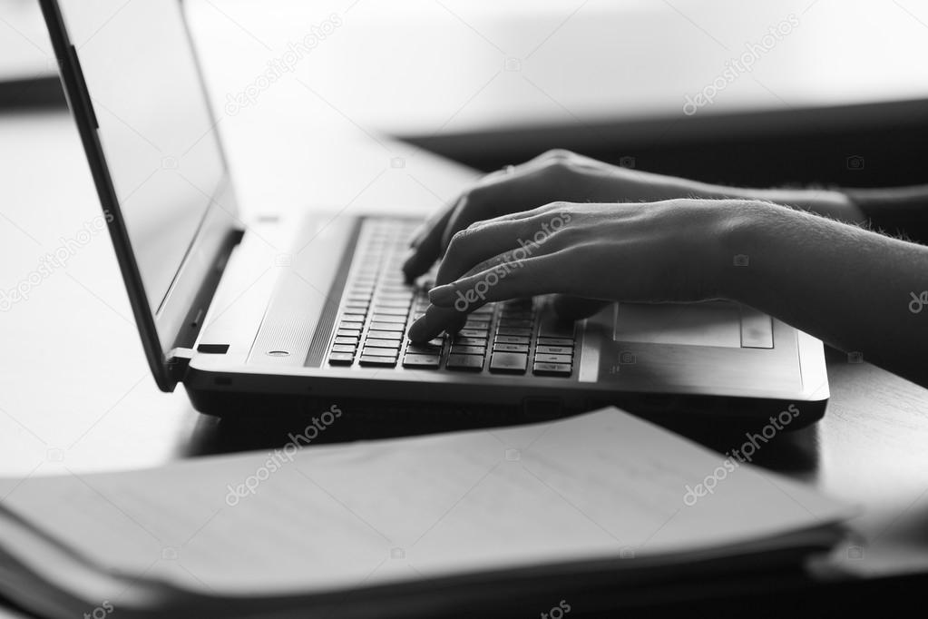 Typing female hands on keyboard. black and white