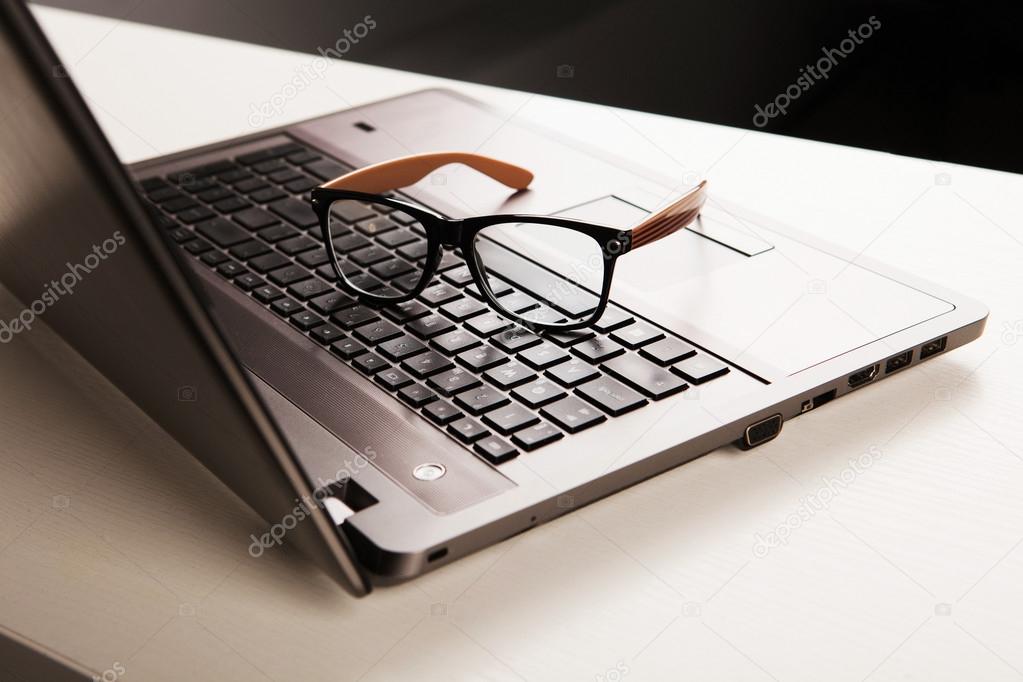 business office workplace. laptop and glasses