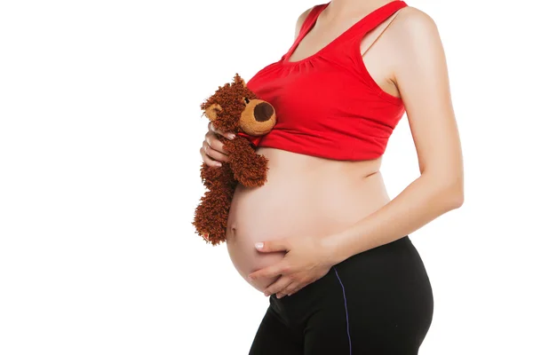 Pregnant woman holding a teddy bear. isolated on white — Stock Photo, Image