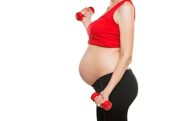 Close-up van gelukkig zwangere vrouw uitoefenen, geïsoleerd op een witte achtergrond, opheffing van halters, actieve levensstijl, gezonde zwangerschap concept — Stockfoto