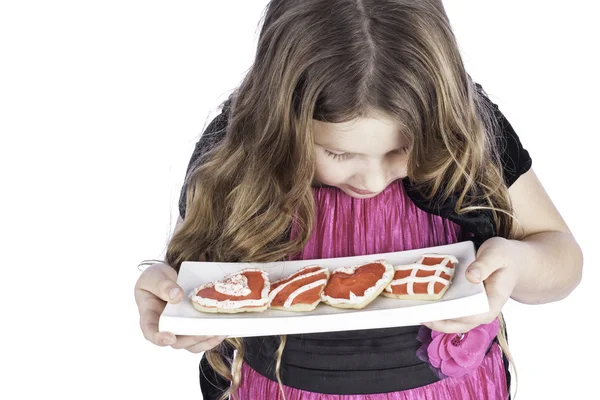 Jovencita sosteniendo plato de galletas de corazón —  Fotos de Stock