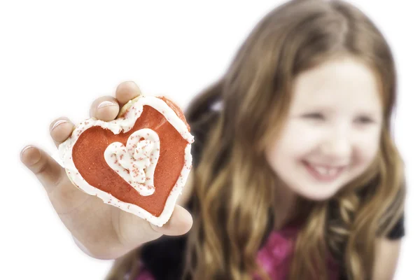 Ung flicka håller en hjärtat cookie — Stockfoto