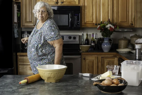 Grandma in a kitchen preparing to bake — Stock Photo, Image