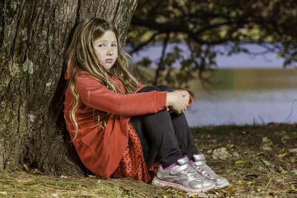 Muchacha triste por el árbol — Foto de Stock