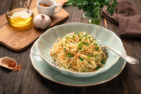 Yakın çekim taze pişmiş spagetti AGLIO E OLIO ve malzemeler