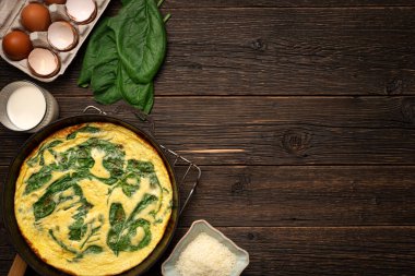 Kızartma tavası SPINACH FRATA ve ana malzemeler ahşap zemin üzerinde kopyalama alanı ile