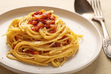 Çatal bıçaklı bir tabakta spagetti carbonara