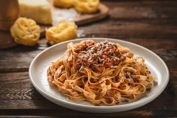 Tahta masadaki BOLOGNESE soslu makarna tagliatelle tabağını kapat.
