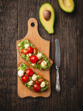 Avocado toast with mozzarella and cherry tomatoes vertical frame