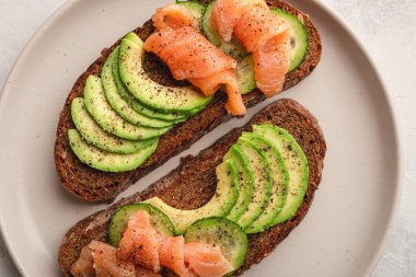 Somon füme ve salatalıklı avokado tostu.