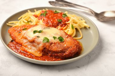 Bir tabak parmesanlı tavuk ve yakın plan spagetti.