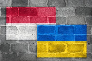 Polonya ve Ukrayna 'nın ulusal bayrakları, işbirliği ve dostluk kavramı olarak tuğla bir duvarda asılı.