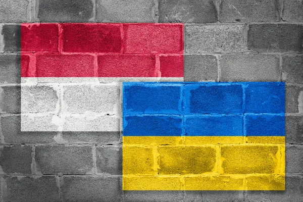National flags of Poland and Ukraine on a brick wall as a concept of cooperation and friendship
