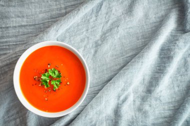 Maydanozlu bir kase domates çorbası.