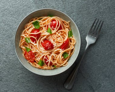 Spaghetti with cherry tomatoes top view on grey slate background