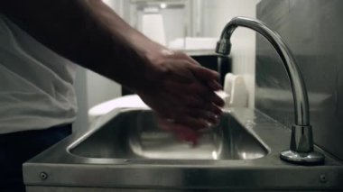 Man washes his hands with soap and clear water. We can see the man rubbing his hands meticulously in the water. Perfect health preventions