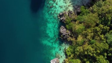 Aerial view with a drone over the Big Lagoon of El Nido in Philippines. We can see the lagoon in the middle of mountains under the blue sky 4K