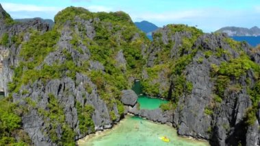 Boats in the middle of the Big Lagoon in El Nido, Philippines. Perfect leisure for travel and paradise summer holidays under the sun - aerial view with a drone 4K