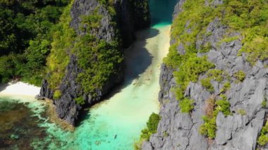 Kayak in the middle of the Big Lagoon of El Nido, Philippines. Perfect leisure for travel and paradise summer holidays under the sun - aerial view with a drone 4K