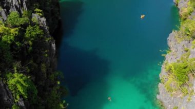 Canoe in the middle of the Big lagoon of El Nido, Philippines. Perfect leisure for travel and paradise summer holidays under the sun - aerial view with a drone 4K