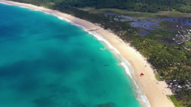 Beach with white-sand of El Nido, Philippines. We can see mountains and palm trees forest in the background, perfect for summer travel in nature - aerial view with a drone 4K