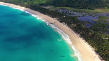 Beach with white-sand of El Nido, Philippines. We can see mountains and palm trees forest in the background, perfect for summer travel in nature - aerial view with a drone 4K