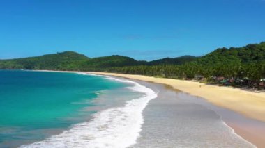 Beach with white-sand of El Nido, Philippines. We can see mountains and palm trees forest in the background, perfect for summer travel in nature - aerial view with a drone 4K