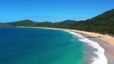 Beach with white-sand of El Nido, Philippines. We can see mountains and palm trees forest in the background, perfect for summer travel in nature - aerial view with a drone 4K