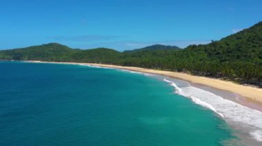 White-sand beach of El Nido, Philippines. We can see mountains and palm trees forest in the background, perfect for summer travel in nature - aerial view with a drone 4K