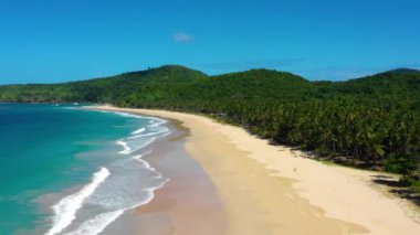White-sand beach of El Nido, Philippines. We can see mountains and palm trees forest in the background, perfect for summer travel in nature - aerial view with a drone 4K