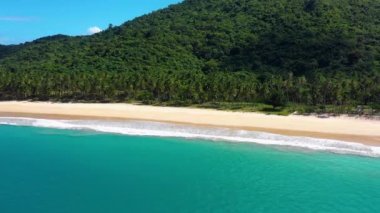 White-sand beach of El Nido, Philippines. We can see mountains and palm trees forest in the background, perfect for summer travel in nature - aerial view with a drone 4K