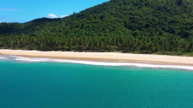 White-sand beach of El Nido, Philippines. We can see mountains and palm trees forest in the background, perfect for summer travel in nature - aerial view with a drone 4K