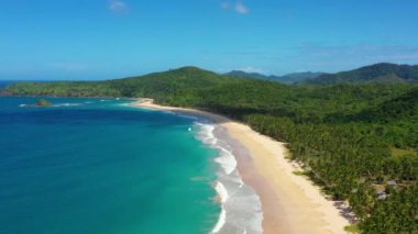 Aerial view of the white-sand beach of El Nido, Philippines. We can see mountains and palm trees forest in the background, perfect for summer travel in nature 4K